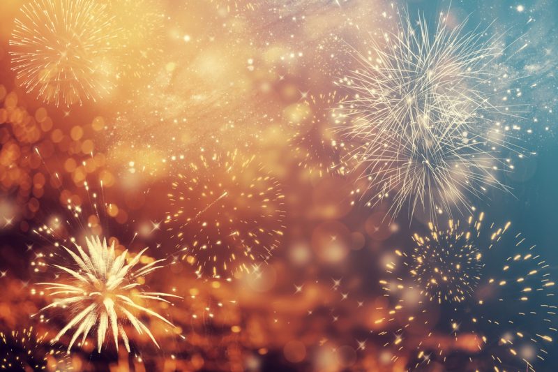 Abstract colorful holiday background of sky with fireworks and stars