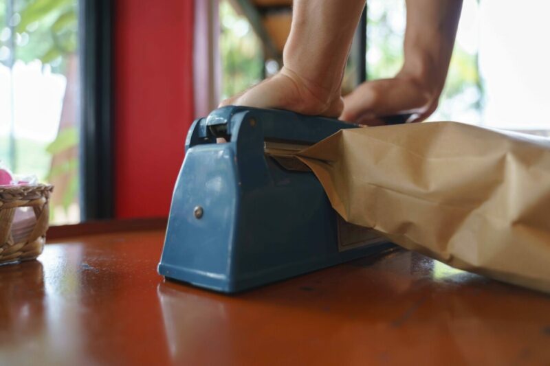 Manual impulse heat sealer for sealing paper bag product