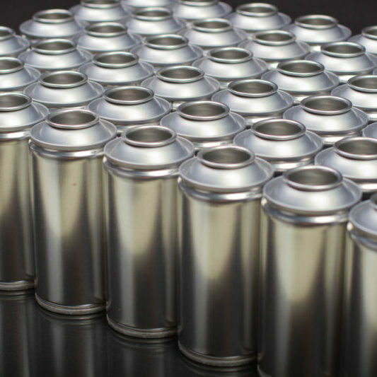 A large number of aerosol cans on a black background.