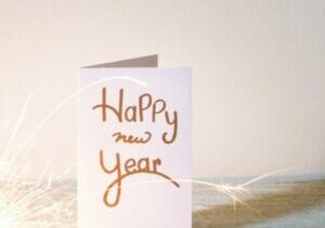 new-year-card-with-lit-sparkler-on-table-against-wall-688969401-5bd668bc46e0fb0026718605-2-800x781